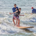 A Surfers Healing volunteer holds on tight to one of the happy participants in the event Wednesday. Photo by Chris Parypa