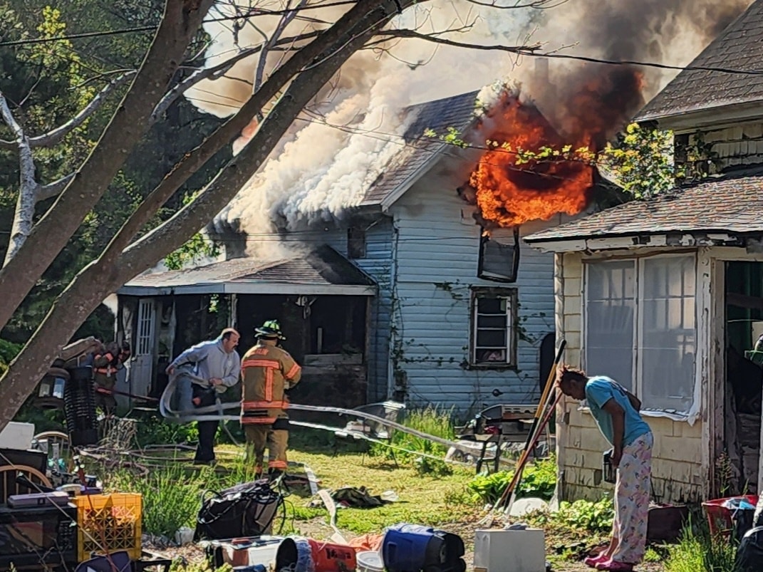 Three people jump out of a burning house